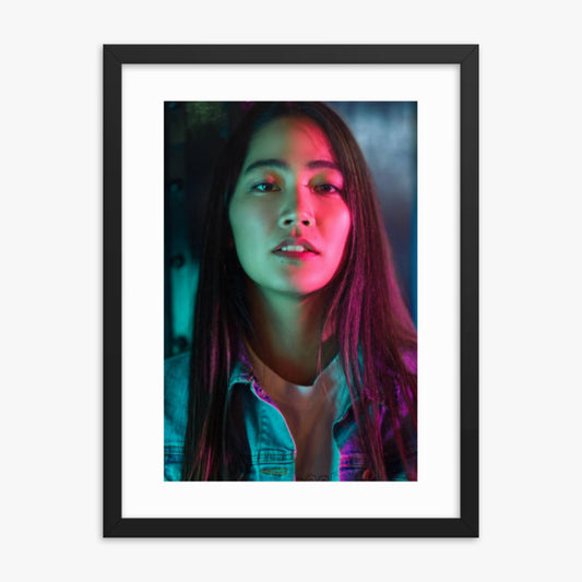 Portrait of young woman lit by colorful neon lights at night 18x24 in Poster With Black Frame